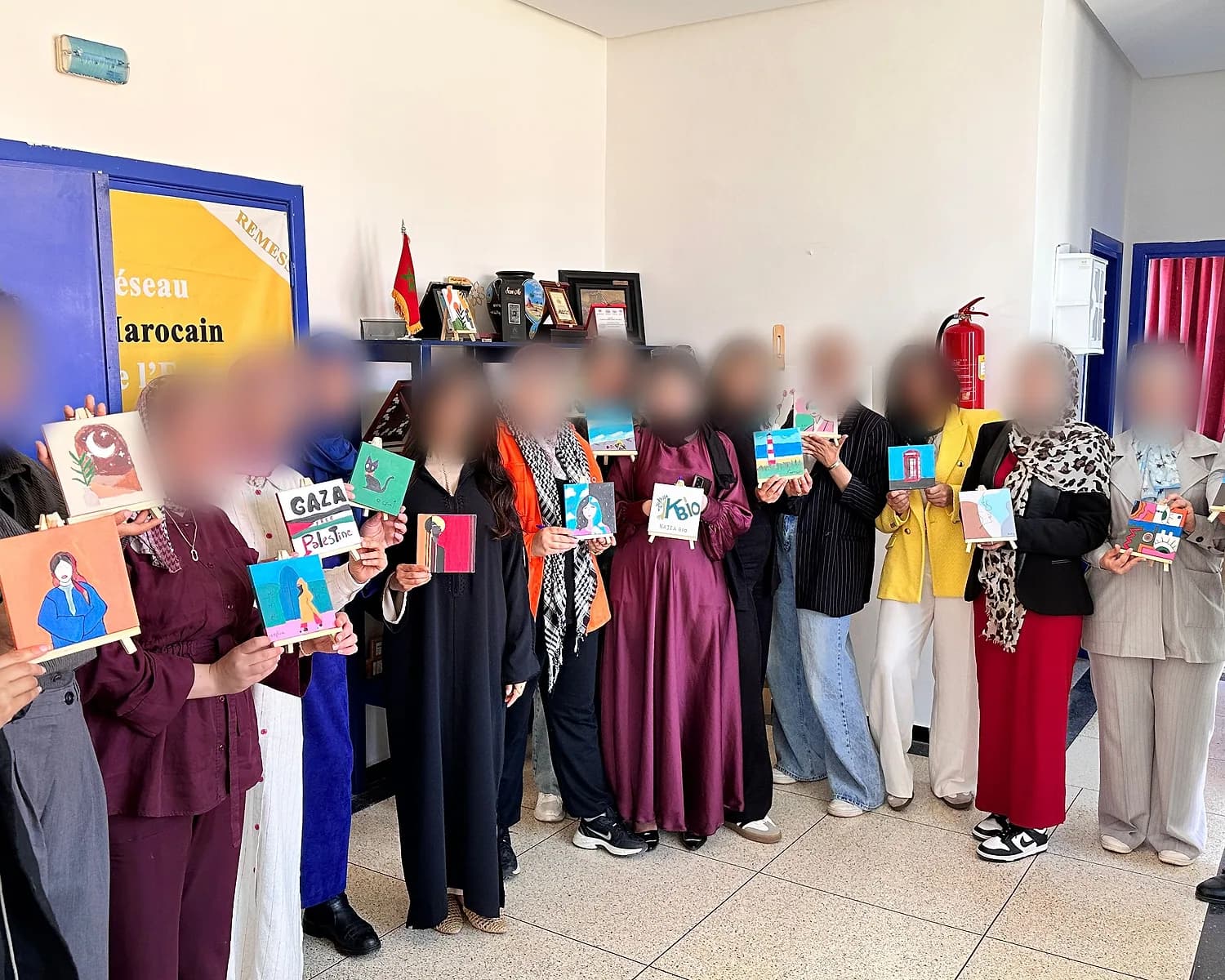 A large group holding up their finished paintings