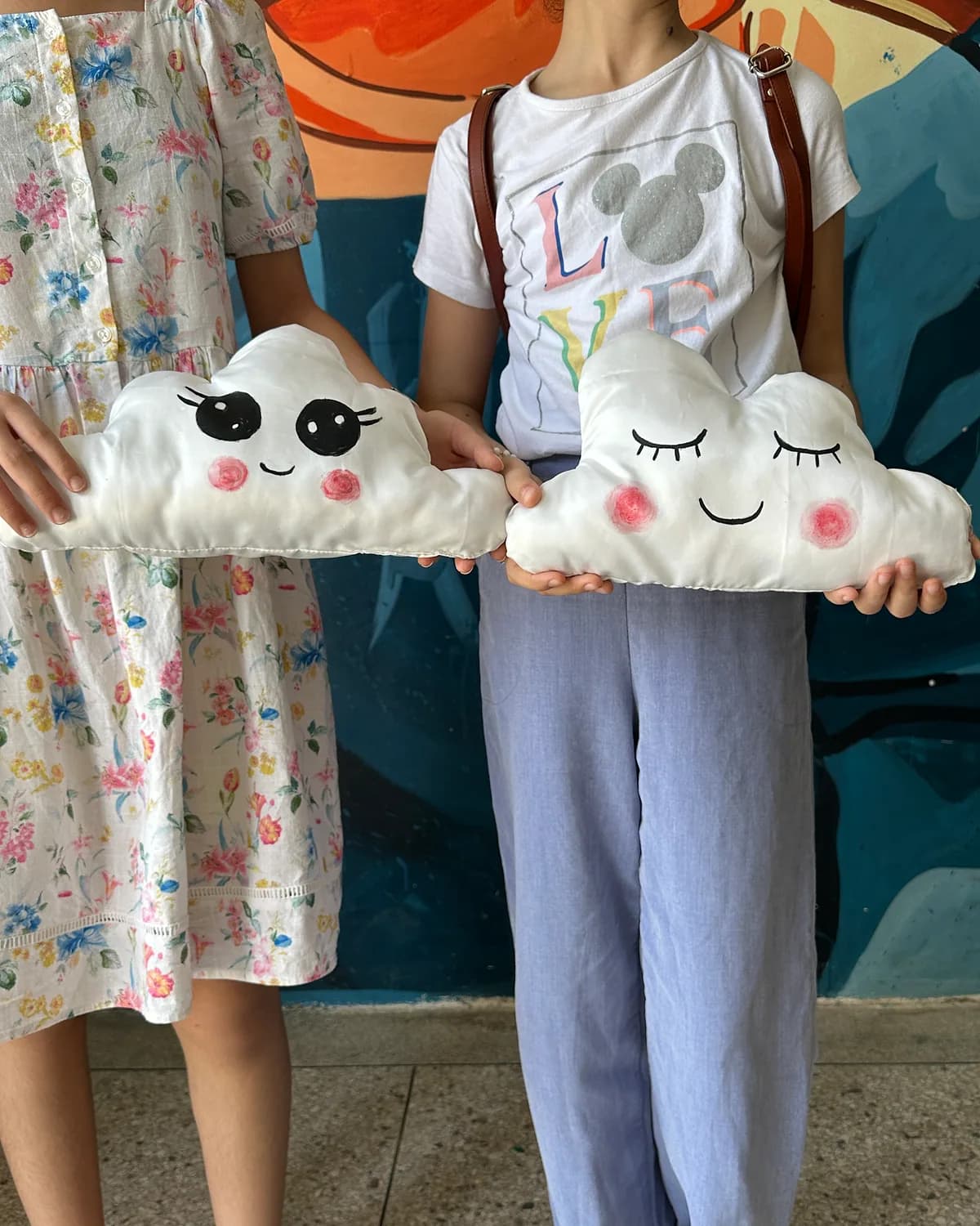 Two children holding their handmade cloud pillows