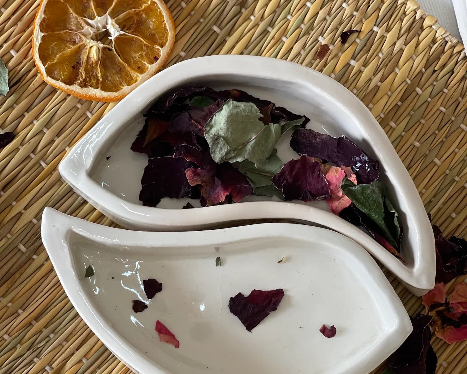 A hand-built dish holding dried rose petals and cinnamon