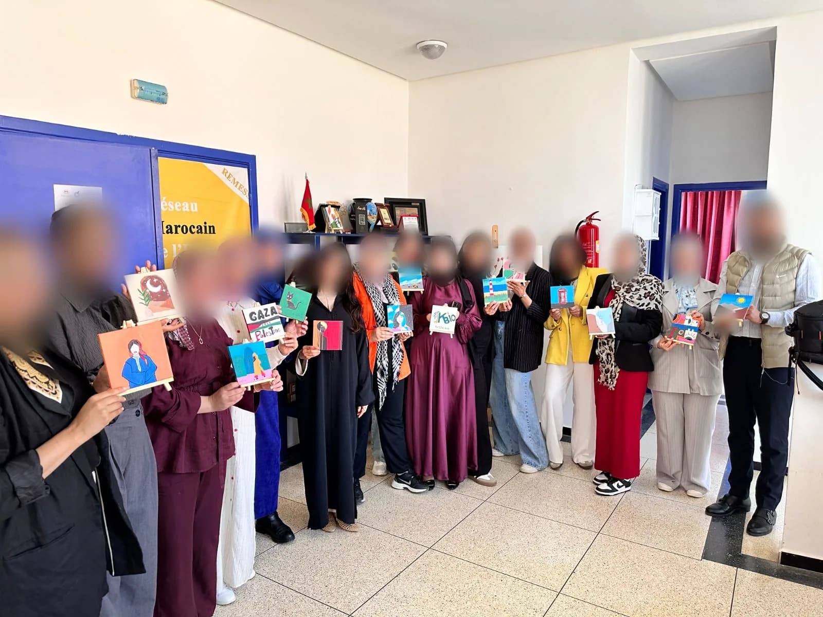 A team holding up their small painted canvases
