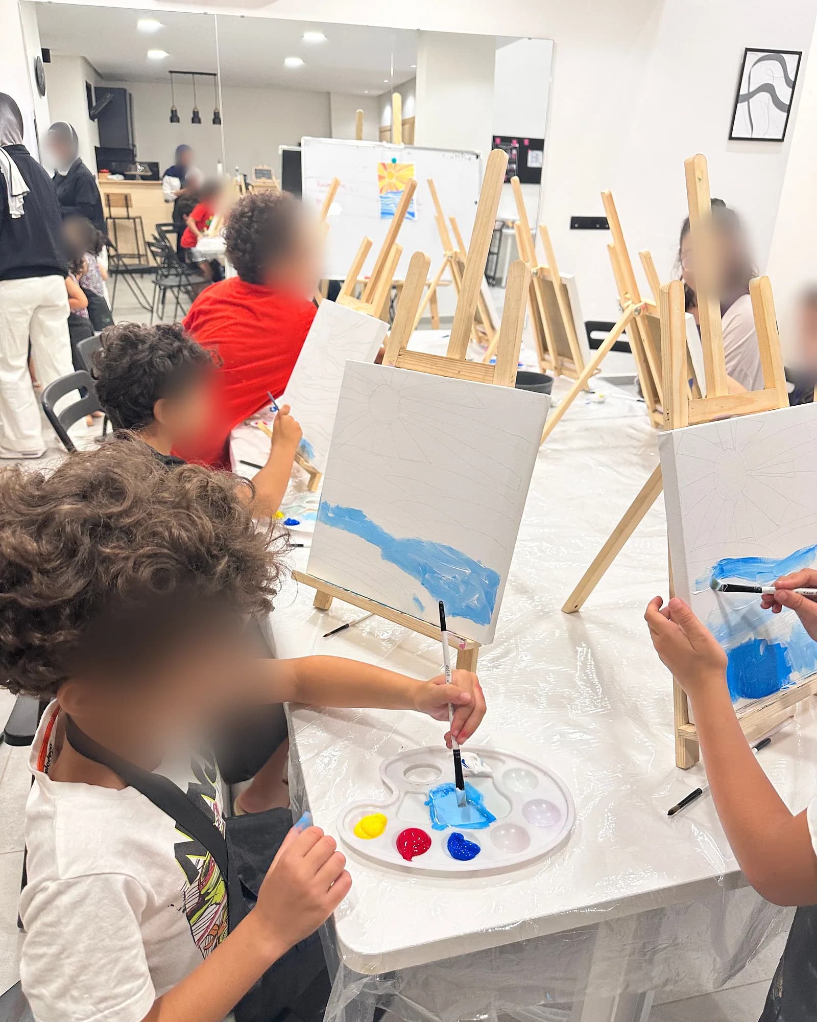 Children painting with bright colours at a Bluhimi Arts kids workshop
