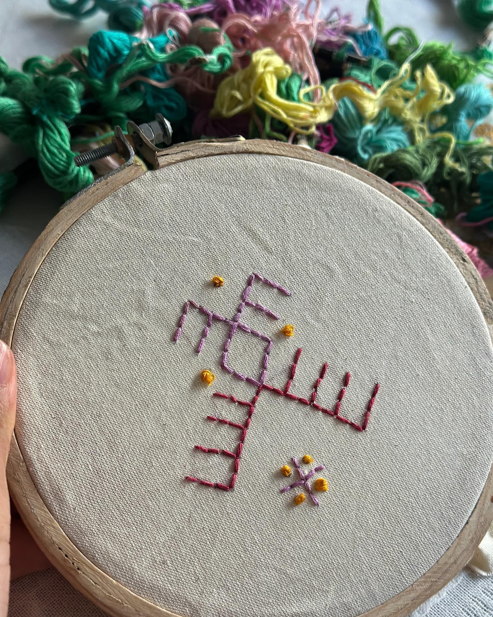 An embroidery hoop with a stitched pattern and colourful yarn – weaving and textile art, arts plastiques workshop