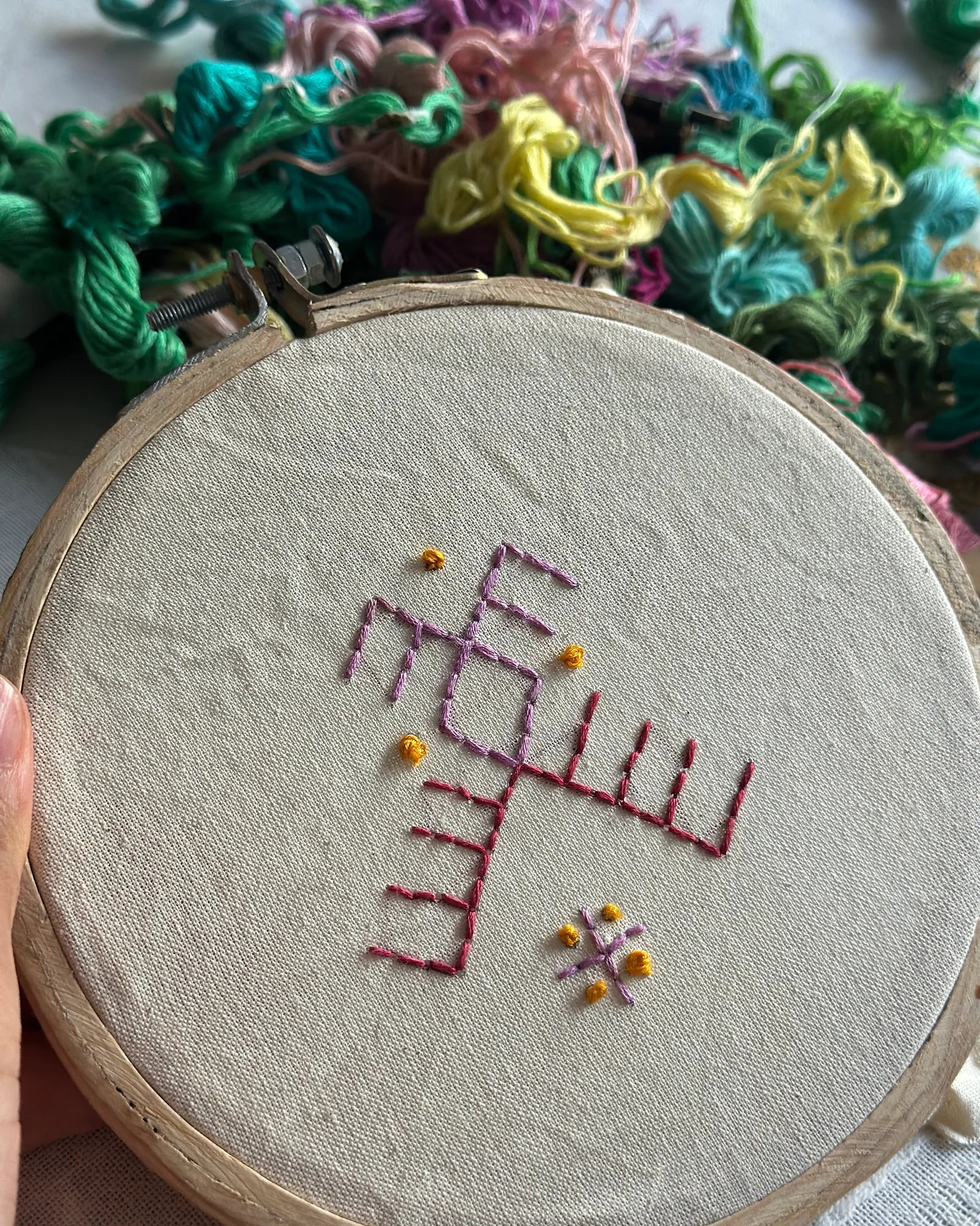 An embroidery hoop with a stitched pattern and colourful yarn – weaving and textile art, arts plastiques workshop